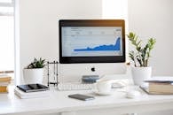 A clean, contemporary workspace featuring a desktop with analytics on the screen and plants for a fresh look.